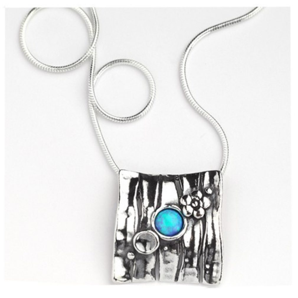 square pendant with small designs and round opal stone